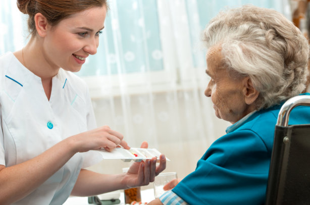 Female nurse giving senior women medical pills