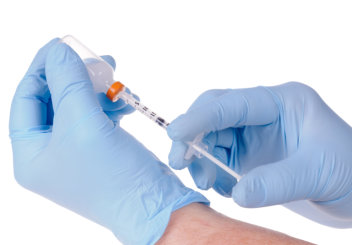 Doctor or nurses gloved hands extracting insulin